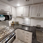 Kitchen oven, range, microwave, cupboards, countertop, and sink